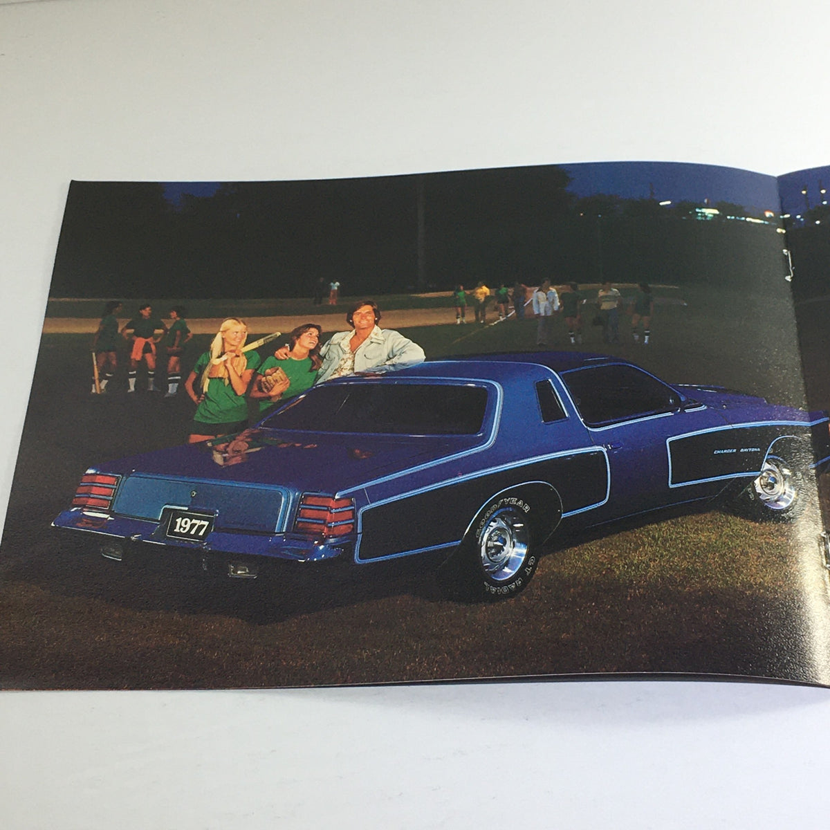 1977 Dodge Charger Specifications - Image showing a purple 1977 Dodge Charger car with people in a park, highlighting the nostalgic appeal of the 1977 Dodge Charger brochure.