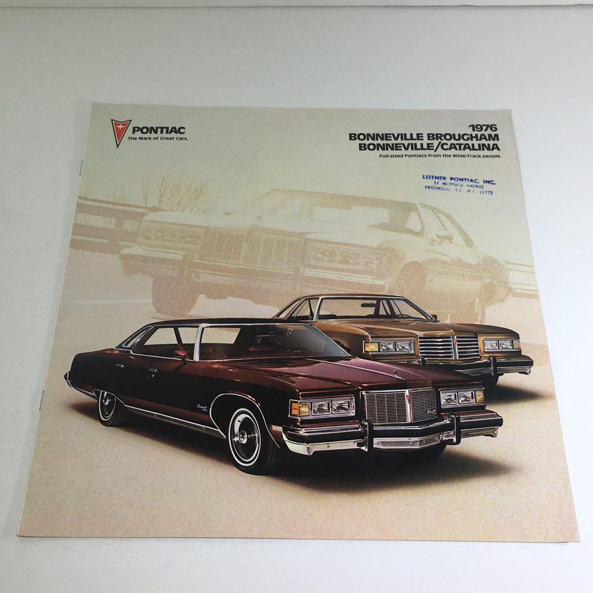 1976 Pontiac Bonneville Brougham Catalina Facts & Figures Auto Brochure featuring a striking image of a burgundy Pontiac Bonneville Brougham in front of another model, showcasing the classic design of full-size Pontiacs.