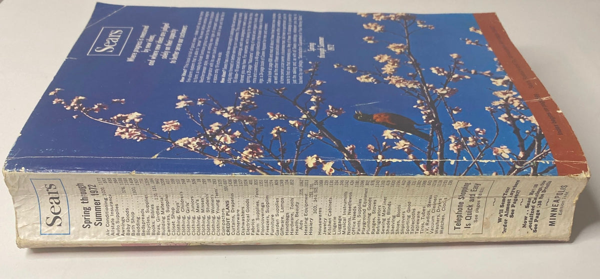 Side view of the 1972 Sears Roebuck and Co. Spring and Summer Catalog showcasing its blue back cover with floral design and visible text sections.