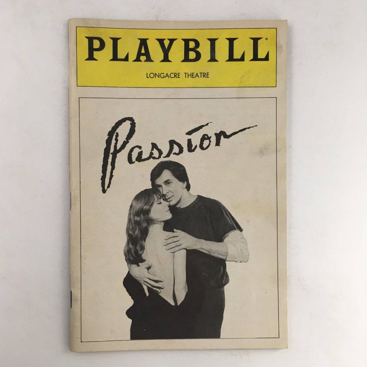 1983 Playbill for Passion by Peter Nichols, featuring a romantic image of the lead characters at Longacre Theatre.