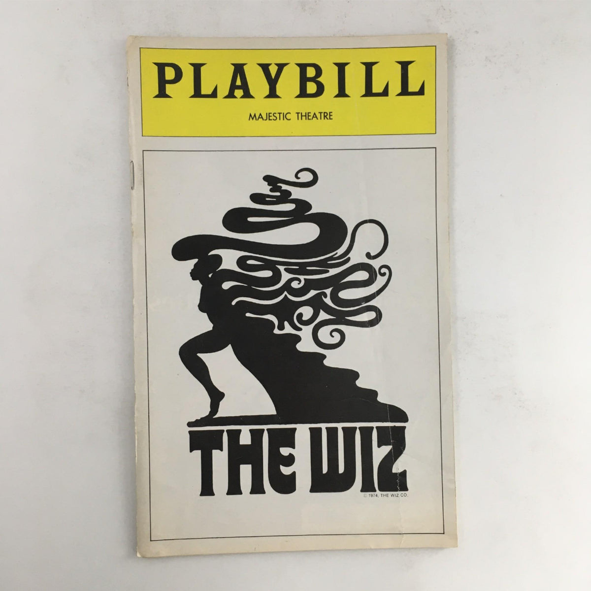 1976 Playbill for The Wiz by Ken Harper and Geoffrey Holder, featuring a striking black silhouette of a woman on the cover, showcasing its artistic design from the Majestic Theatre.