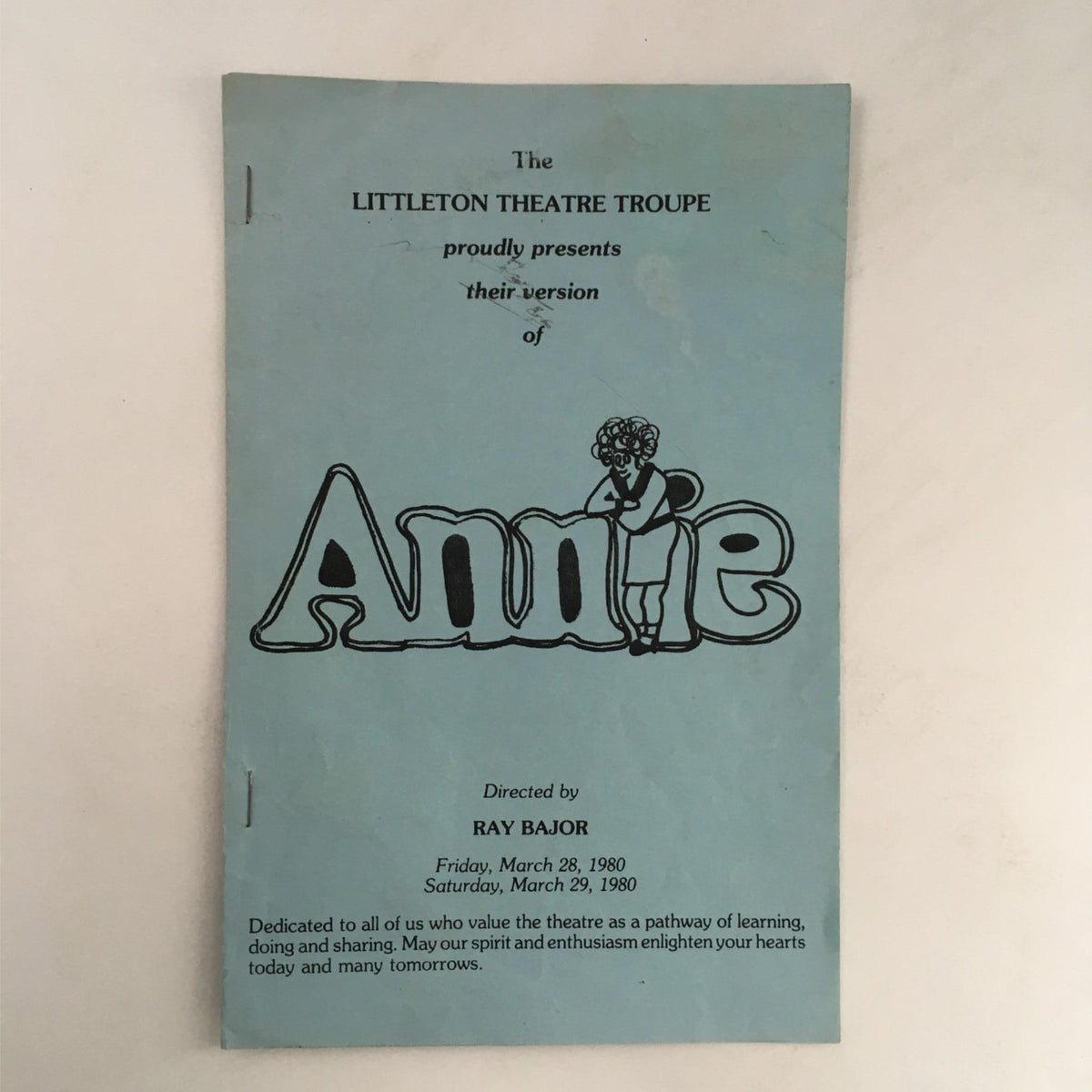 Cover of the 1980 Annie program by Ray Bajor at Littleton Theatre Troupe, featuring colorful illustration and event details; a nostalgic piece for theatre enthusiasts.