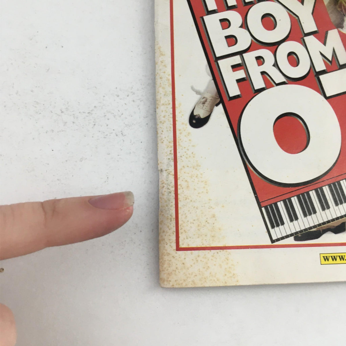 Close-up image showing the wear and tear on the 2003 Playbill for 'The Boy from OZ', highlighting stains and marks on the cover.