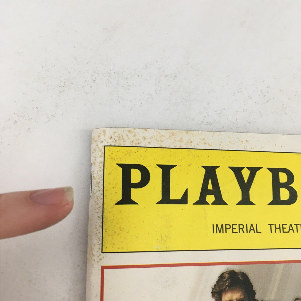Detail of the top corner of the 2003 'The Boy from OZ' Playbill, illustrating discoloration and fading, indicative of its age.