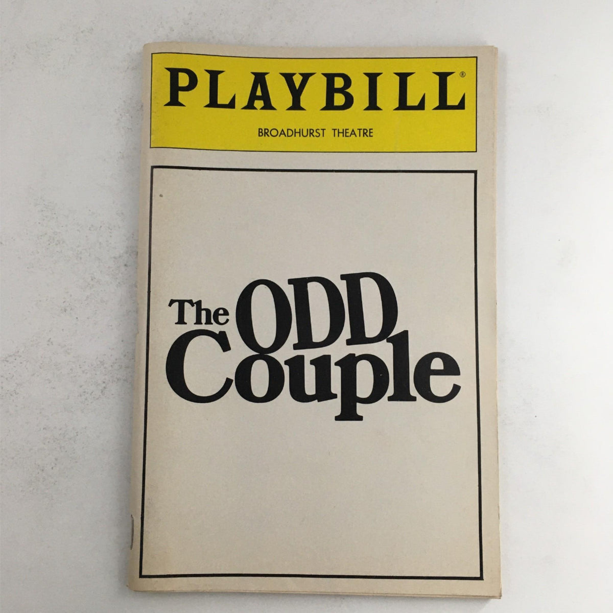 1985 Playbill for The Odd Couple by Neil Simon at Broadhurst Theatre, showcasing the front cover with bold title and theater branding.
