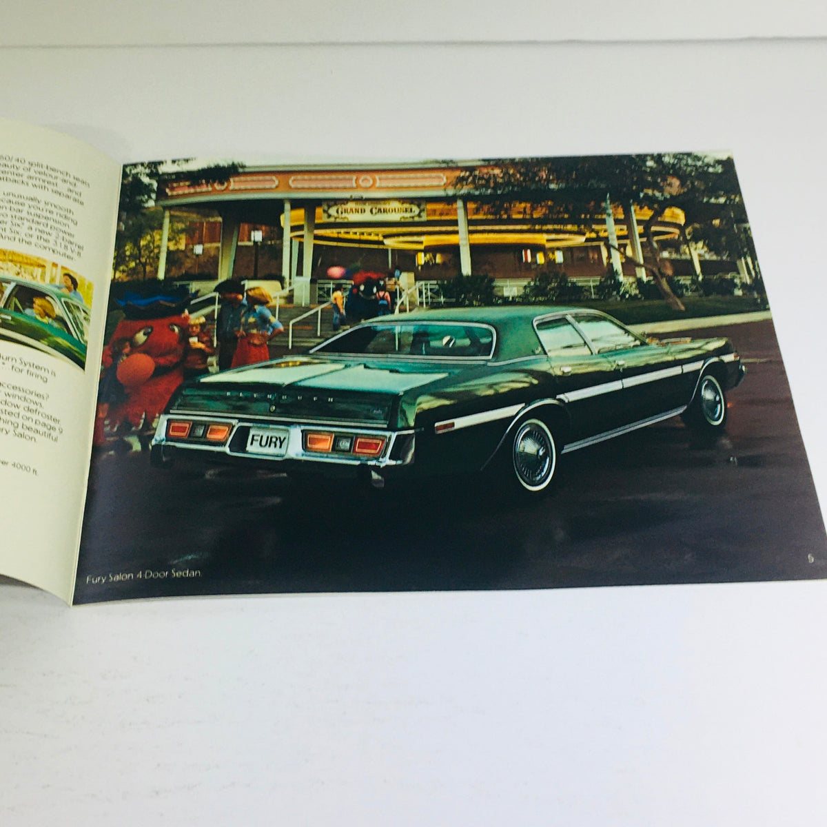 1977 Plymouth Fury Sport-Salon-Fury Dealership Car Auto Brochure featuring a green Plymouth Fury parked near a colorful carnival scene.