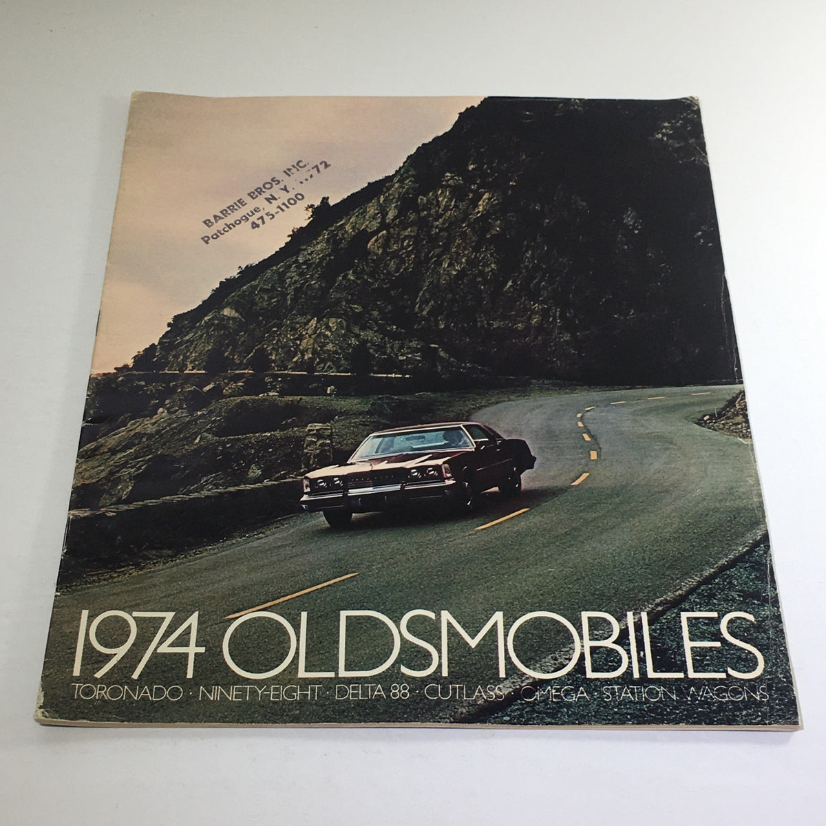 1974 Oldsmobile Toronado-Ninety-Eight Dealership Car Auto Brochure Catalog cover featuring a classic Oldsmobile driving on a scenic mountain road.
