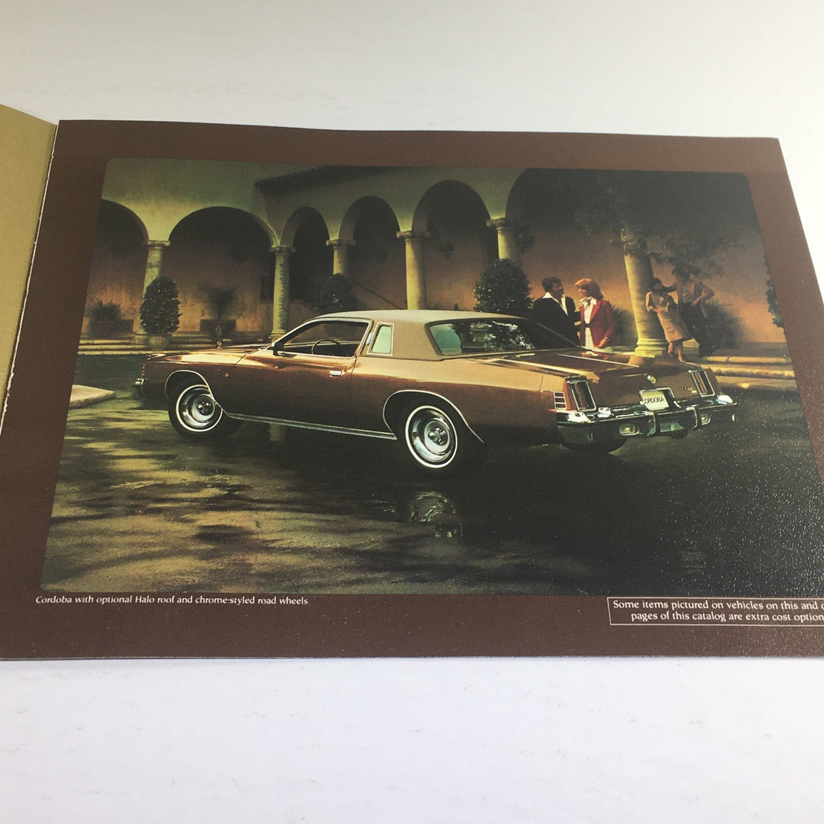 Side view of a 1977 Chrysler Cordoba parked outside, highlighting its features and optional amenities, included in the 1977 Chrysler Cordoba Halo Roof Dealership Car Auto Brochure Catalog.