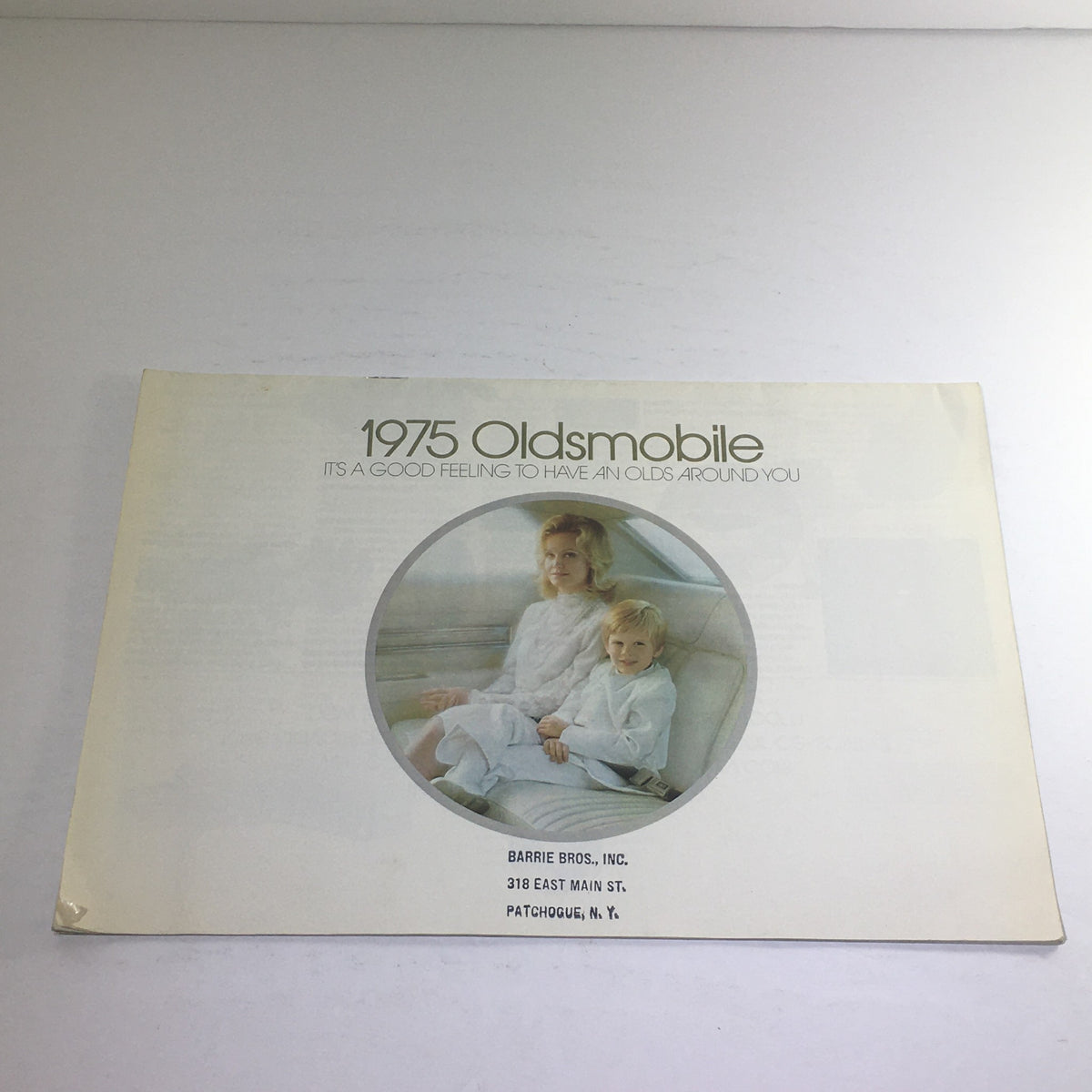 1975 Oldsmobile Supreme Omega Dealership Sale Car Auto Brochure Catalog cover featuring a woman and child sitting inside a vehicle.
