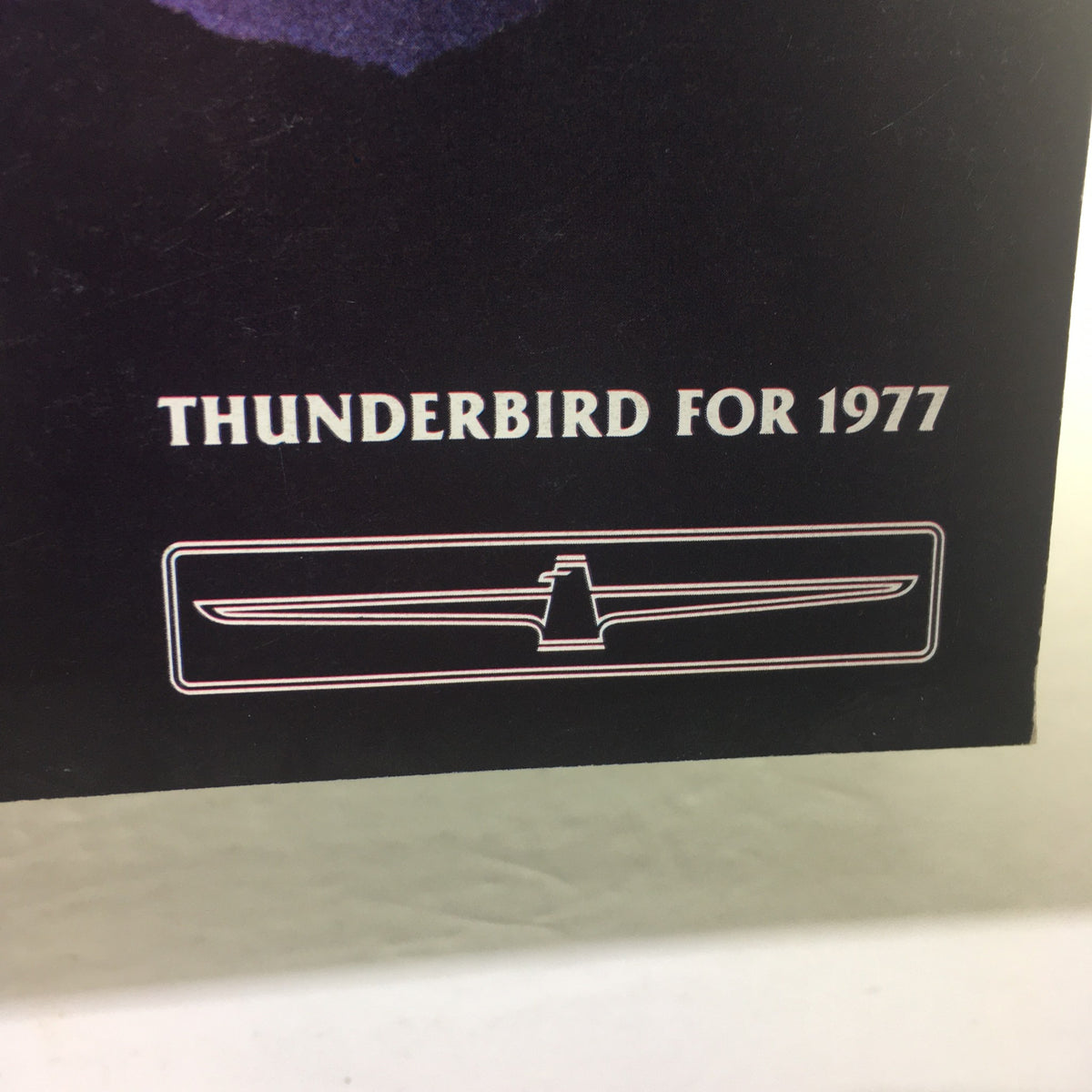 Detail of the 1977 Ford Thunderbird image showcasing the logo 'THUNDERBIRD FOR 1977' prominently displayed on the catalog.