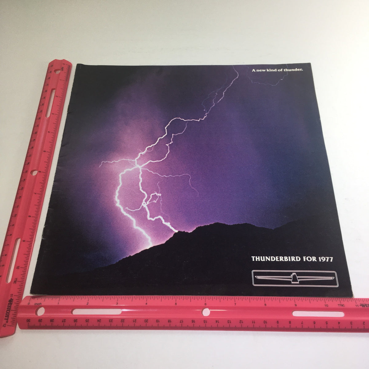 Front cover of the 1977 Ford Thunderbird Deluxe Dealership Car Auto Brochure Catalog, showcasing dramatic lightning imagery with the tagline 'A new kind of thunder'.