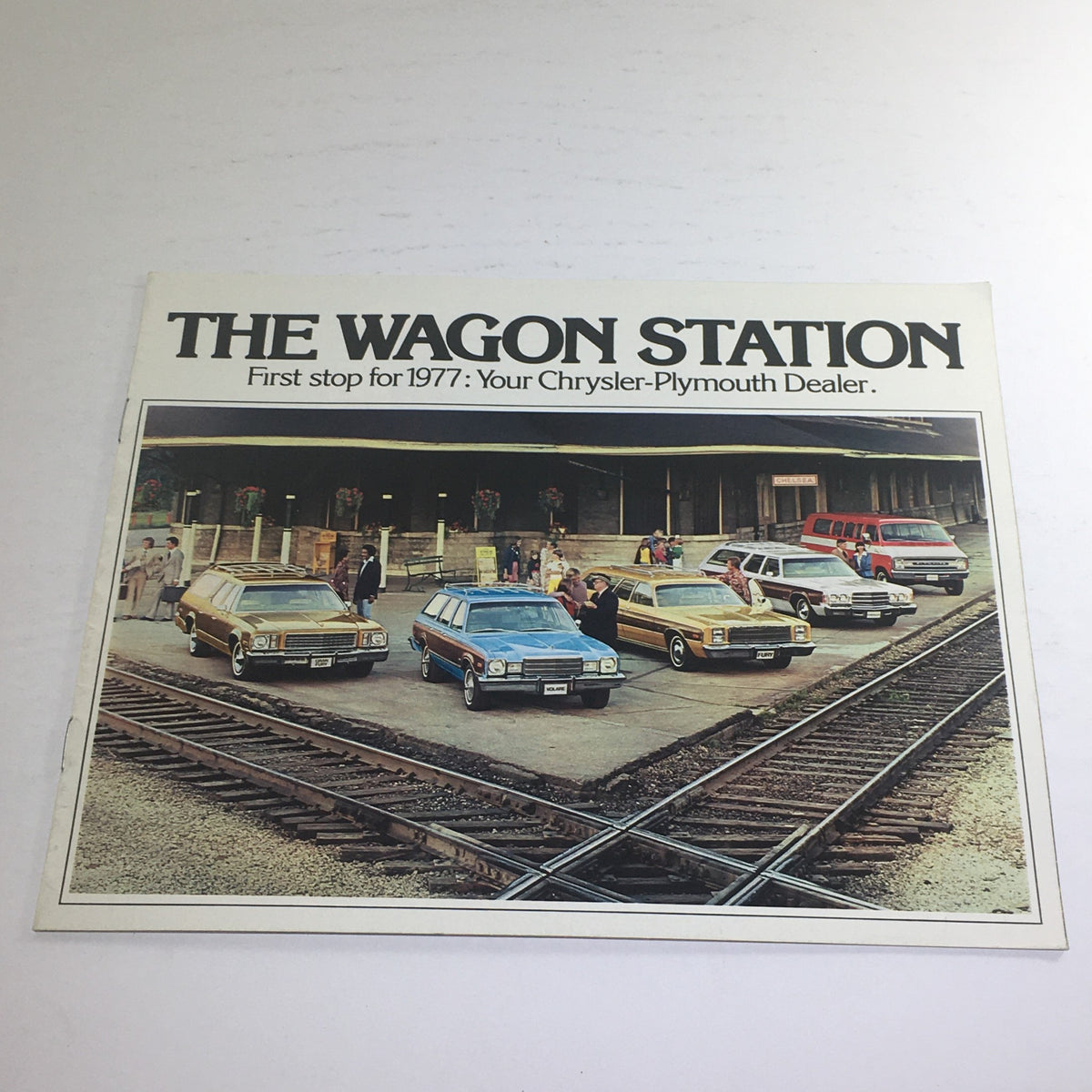 1977 Chrysler-Plymouth Wagon Station Dealership Sale Car Auto Brochure Catalog featuring a display of various Chrysler-Plymouth Wagon models at a dealership.