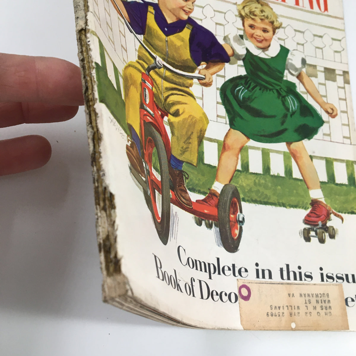 Side view of Good Housekeeping Magazine August 1952, showing the magazine's spine and front cover with kids on a tricycle and roller skates.