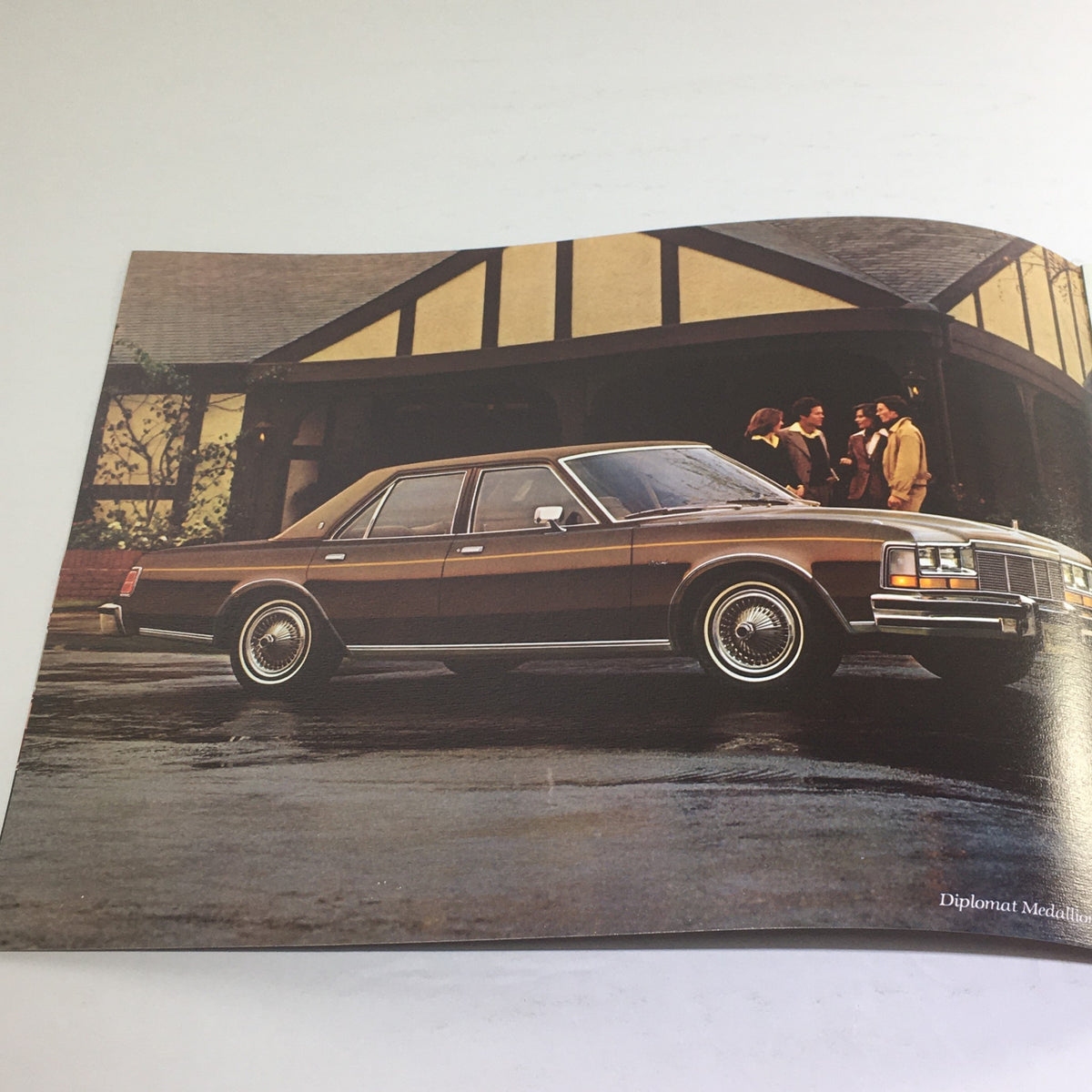 1978 Dodge Diplomat Medallion Dealership Advertising Car Auto Brochure Catalog showcasing a brown Dodge Diplomat parked in front of a house with people interacting.