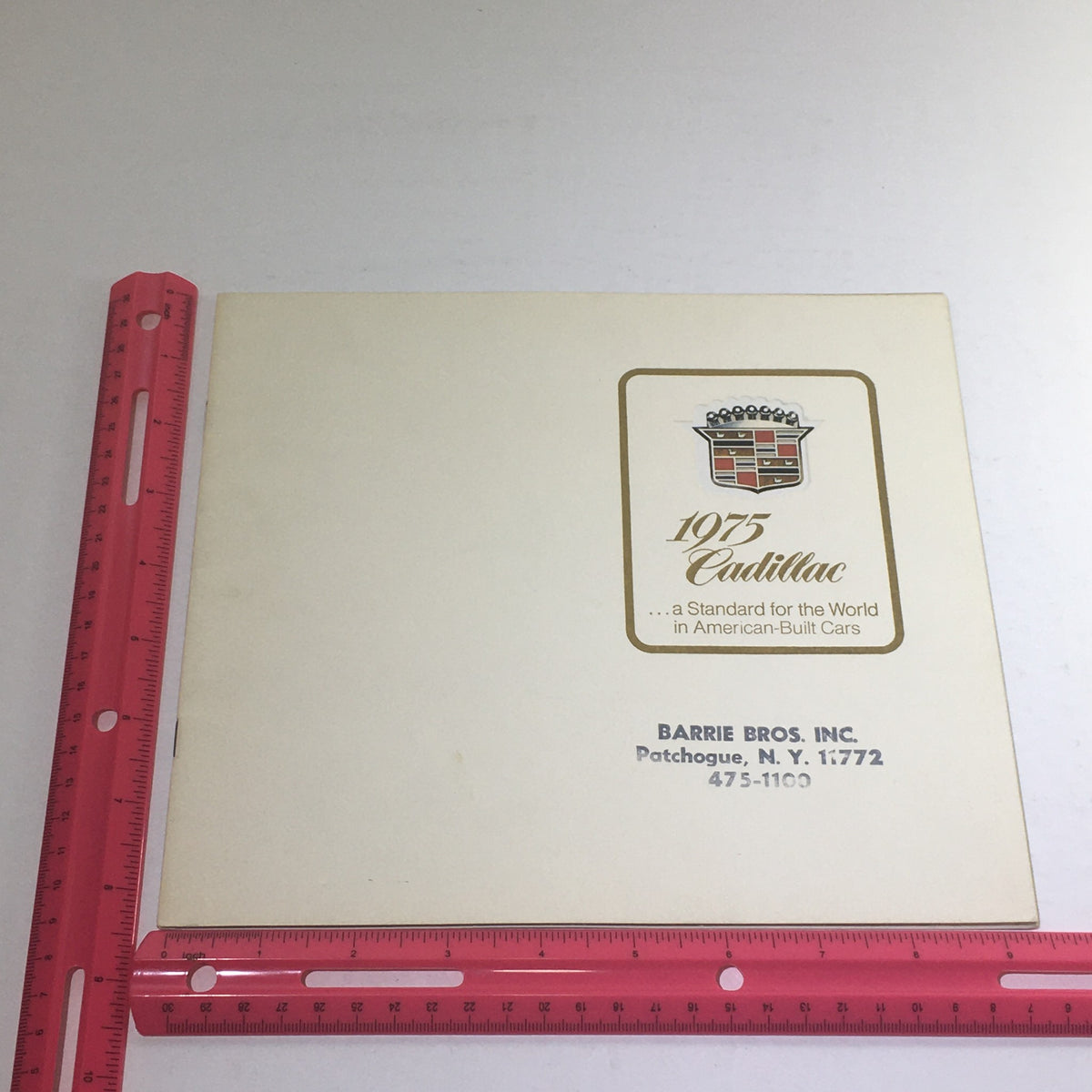 1975 Cadillac American-Built Showroom Dealership Car Auto Brochure Catalog cover featuring the logo and branding, with dimensional markings and text detailing the dealership location, original condition rating, and promotional taglines about American-built cars.