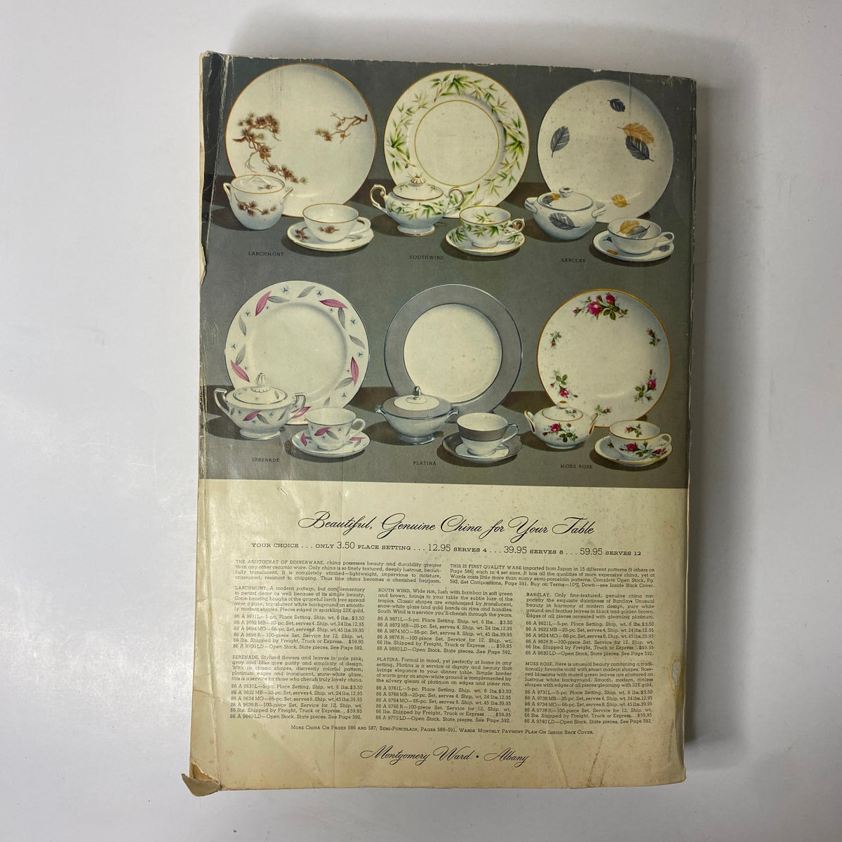 Cover page of the 1956 - 1957 Montgomery Ward Fall and Winter Catalog featuring beautiful china tableware including plates and cups, with accompanying text highlighting the elegance of vintage design.