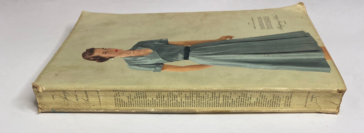 Side view of the 1952 Montgomery Ward Albany Spring and Summer Catalog, illustrating the vintage design featuring a woman in a blue dress typical of the 1950s fashion.