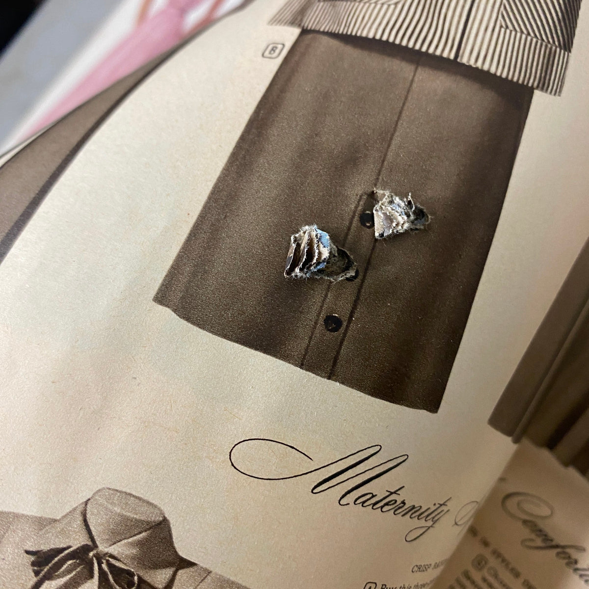Another close-up of a damaged page in the 1952 Montgomery Ward Albany Spring and Summer Catalog, revealing details of a maternity dress with visible imperfections.