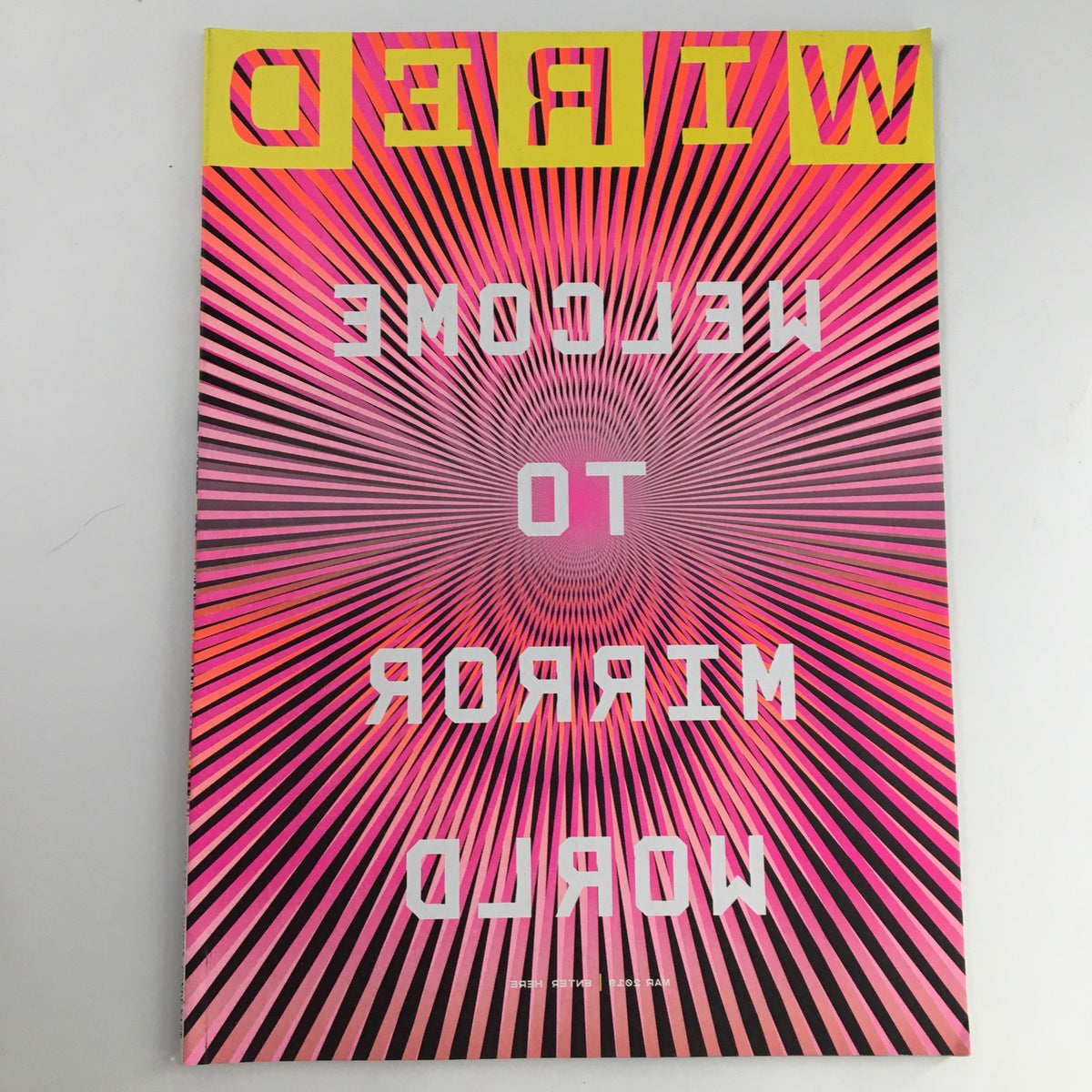 Cover of Wired Magazine March 2019 titled 'Welcome To The Mirror World', featuring a vibrant design with pink and yellow colors and a radial pattern.
