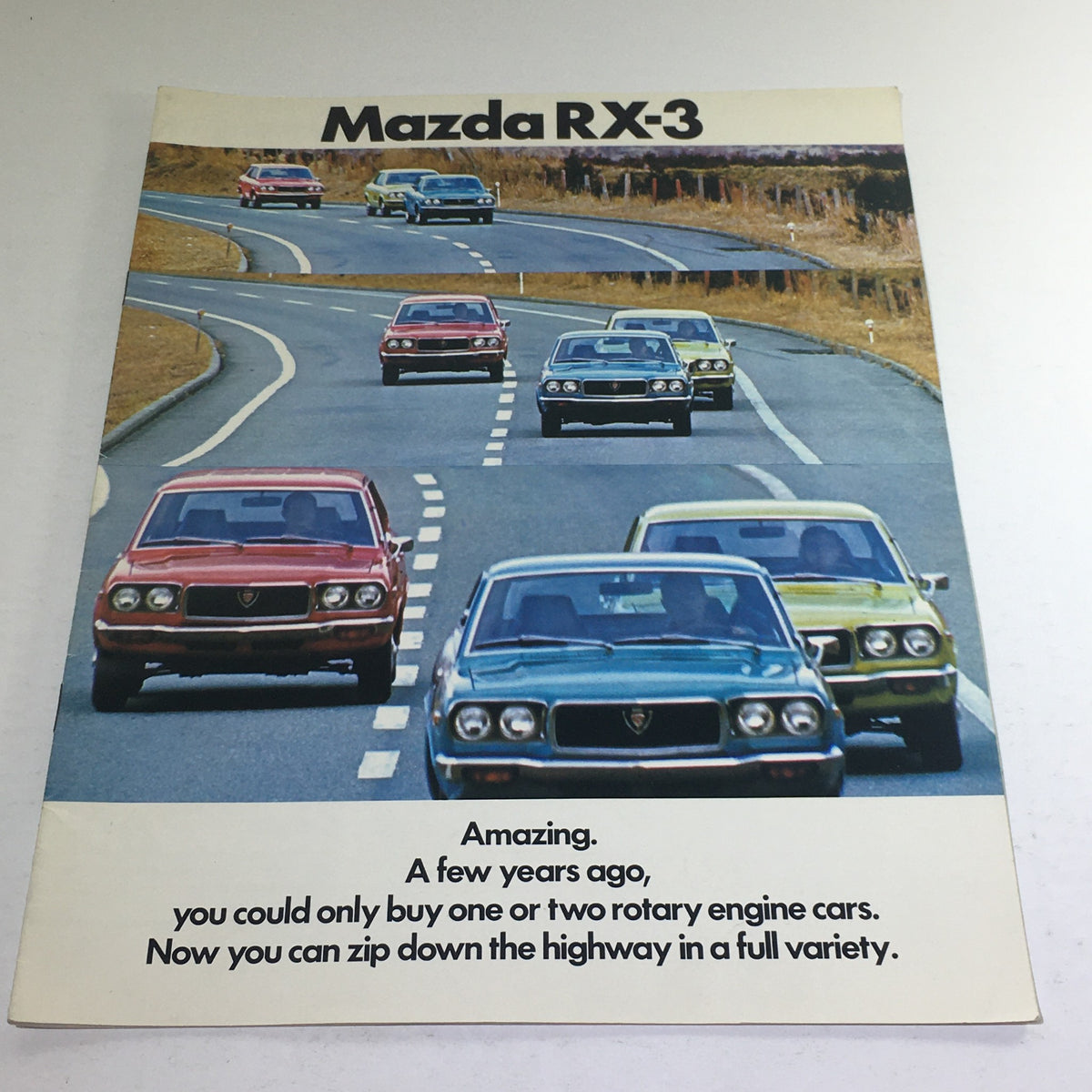 Cover of the 1973 Mazda RX-3 Coupe Sedan Station Wagon Dealership Car Auto Brochure showing various Mazda RX-3 cars on a winding road.