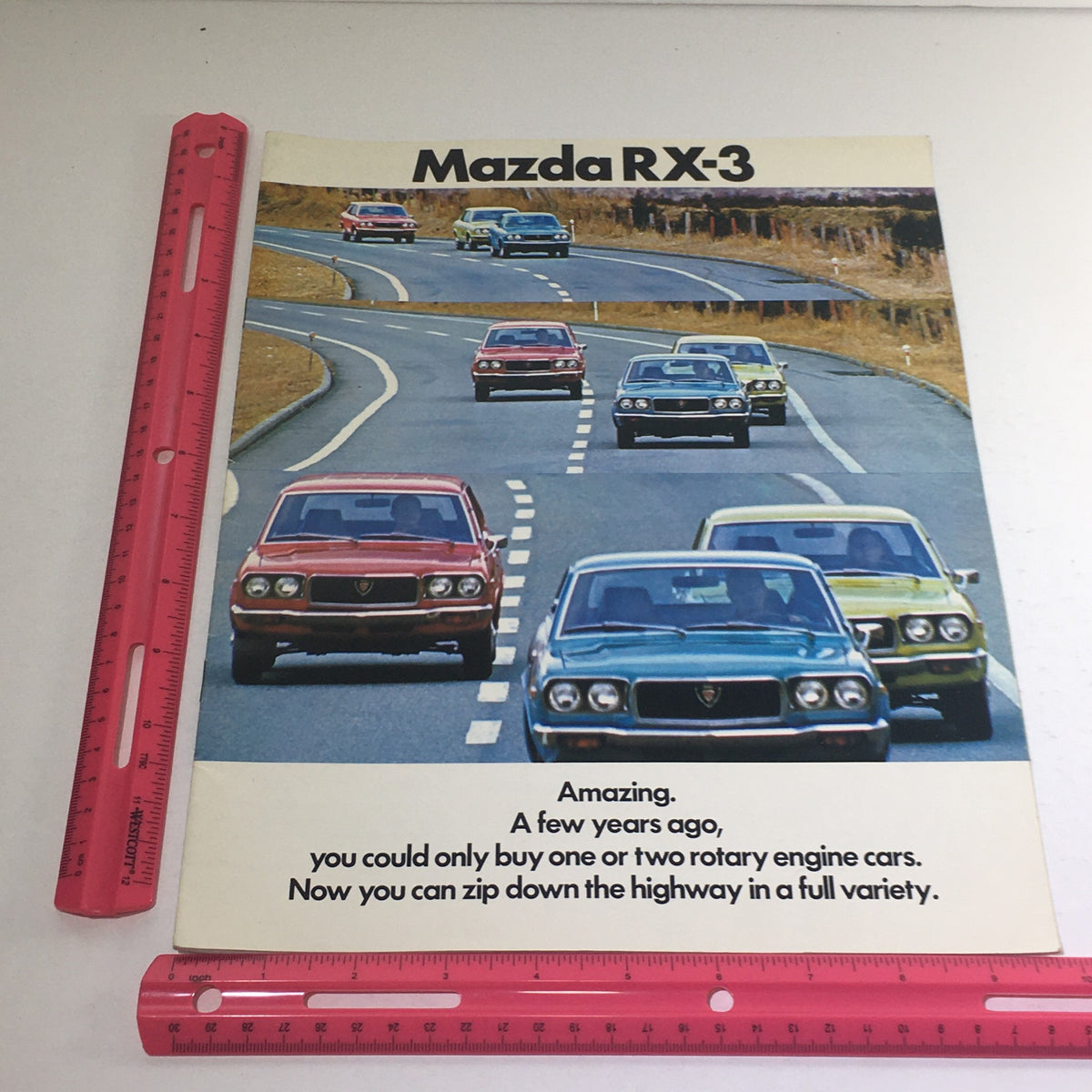1973 Mazda RX-3 Coupe Sedan Station Wagon Dealership Car Auto Brochure Catalog featuring various Mazda models driving on a highway, emphasizing the diversity of the lineup.