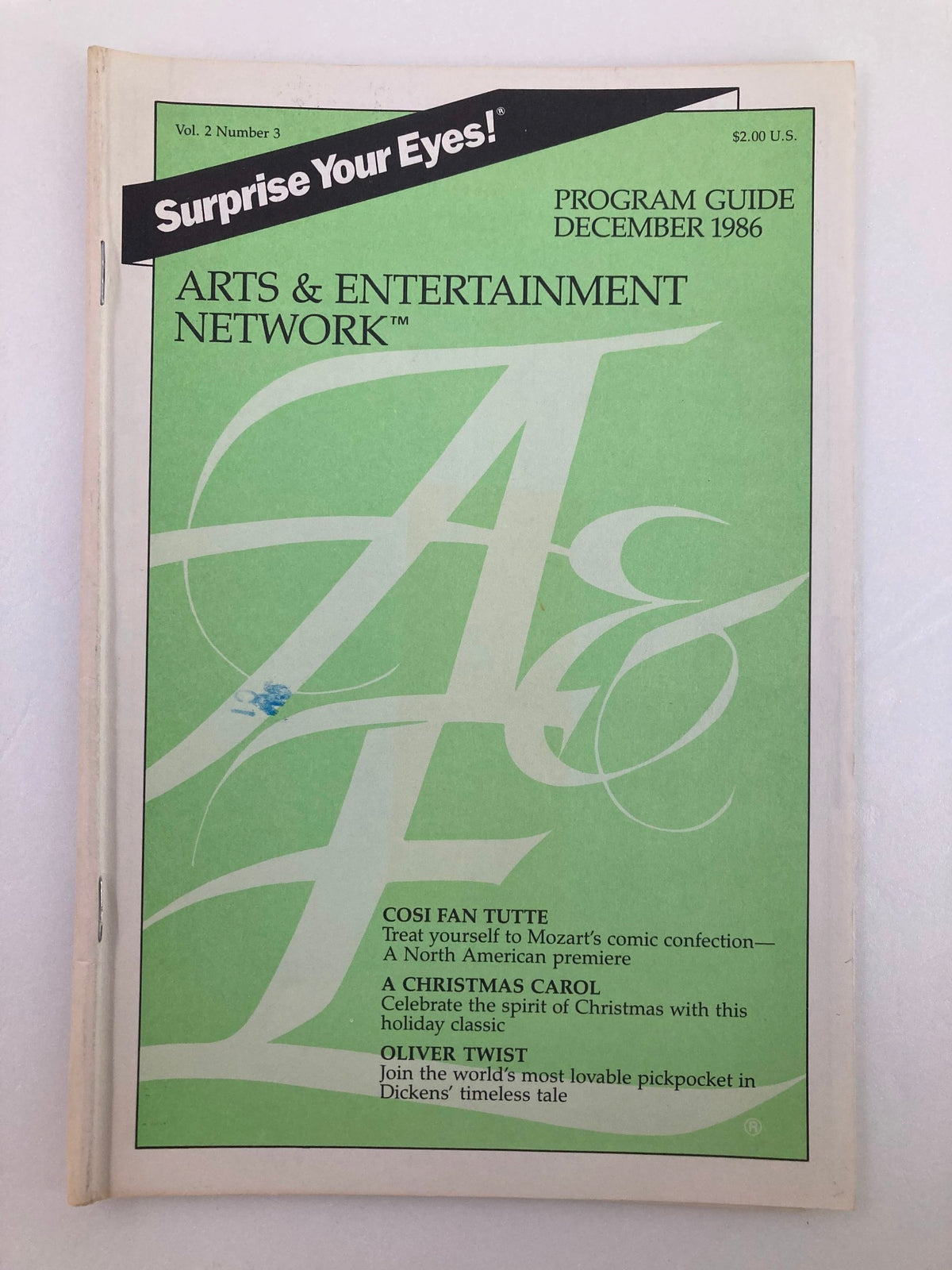 Cover image of December 1986 Vol 2 #3 Program Guide from the Arts & Entertainment Cable Network, featuring the magazine's title and highlights of the issue including 'Cosi Fan Tutte', 'A Christmas Carol', and 'Oliver Twist'.