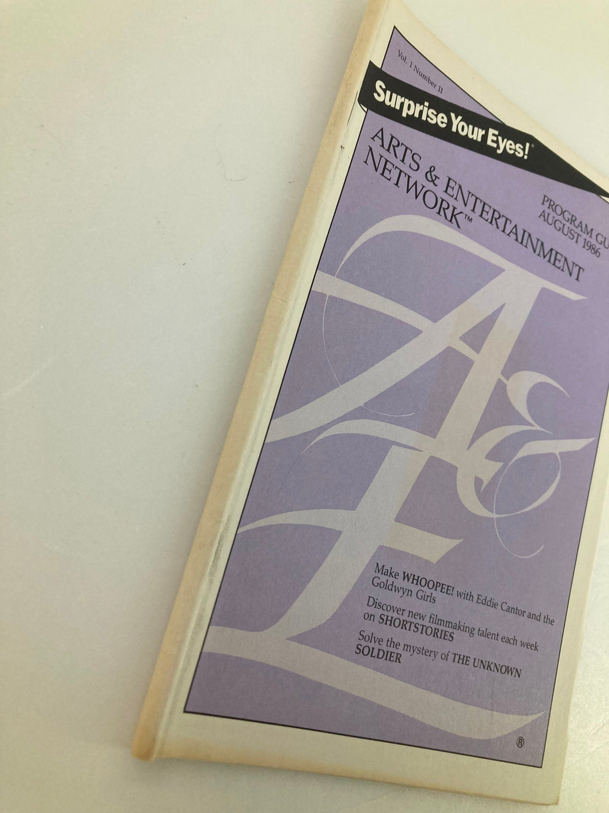 Cover of the VTG A&E Cable Network Program Guide August 1986 Vol 1 #11 featuring the title 'Surprise Your Eyes!' and highlighting shows like 'Whoopee!' starring Eddie Cantor.