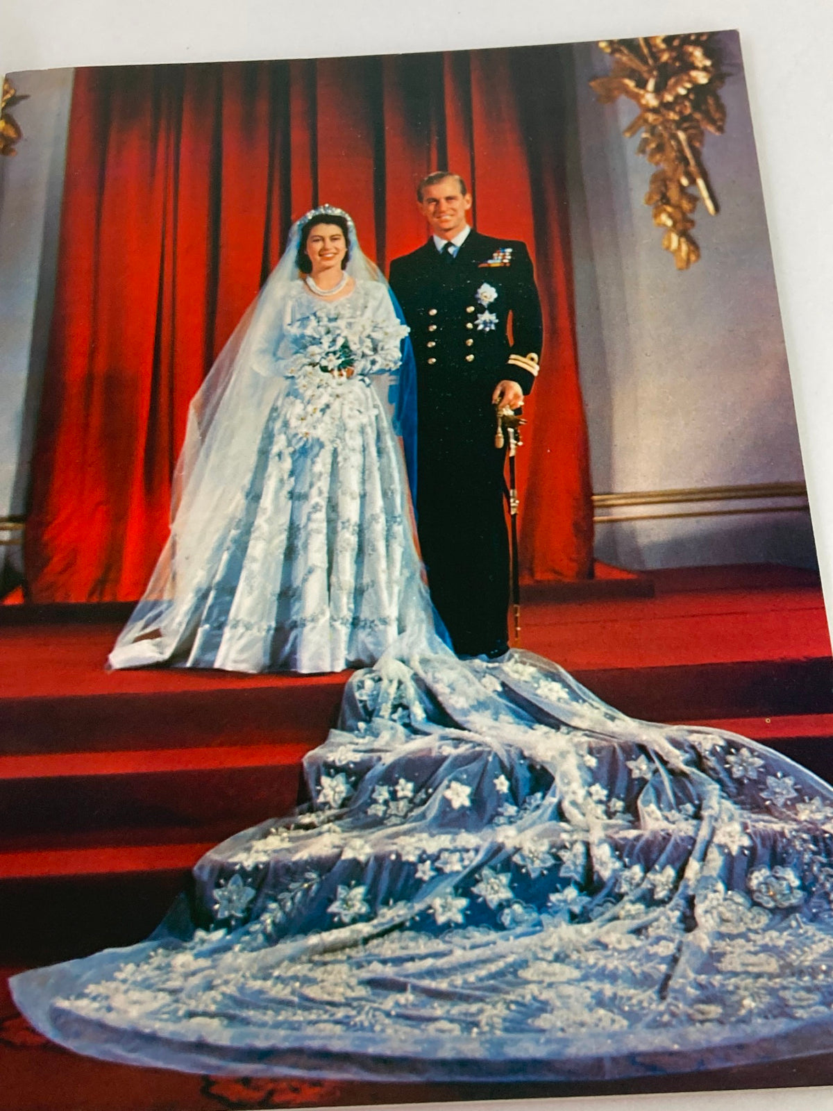 Image from the VTG Royal Family Souvenir 1973 Picture Book capturing the wedding moment of Queen Elizabeth II and Prince Philip, showcasing the bride's stunning blue dress and long veil.