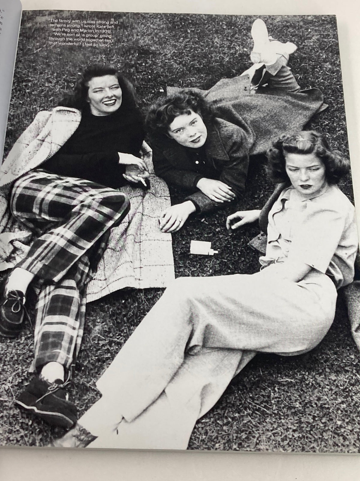 Image from People Magazine Tribute Commemorative Issue Katharine Hepburn 1907-2003 showing three women lounging on the grass, dressed in vintage fashion.