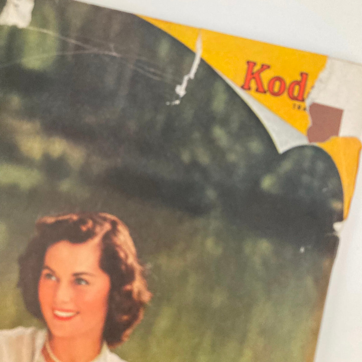 Close-up of the top section of the back cover of the Saturday Evening Post Magazine dated April 15, 1950, showcasing a Kodak logo and part of the illustration by John Clymer.