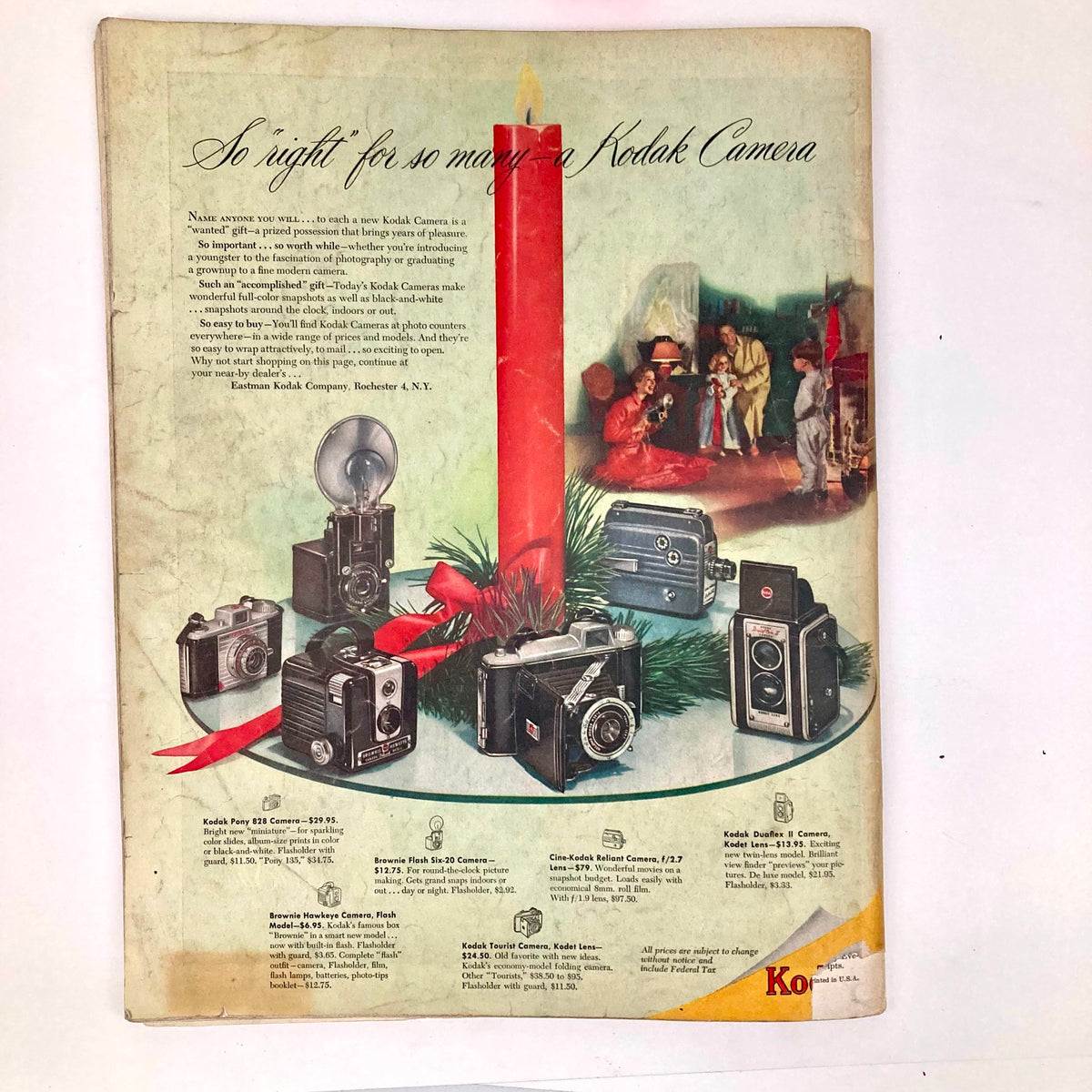 Kodak camera advertisement showcasing various models for gift-giving, set against a festive holiday background, from the December 1950 issue of Saturday Evening Post magazine.