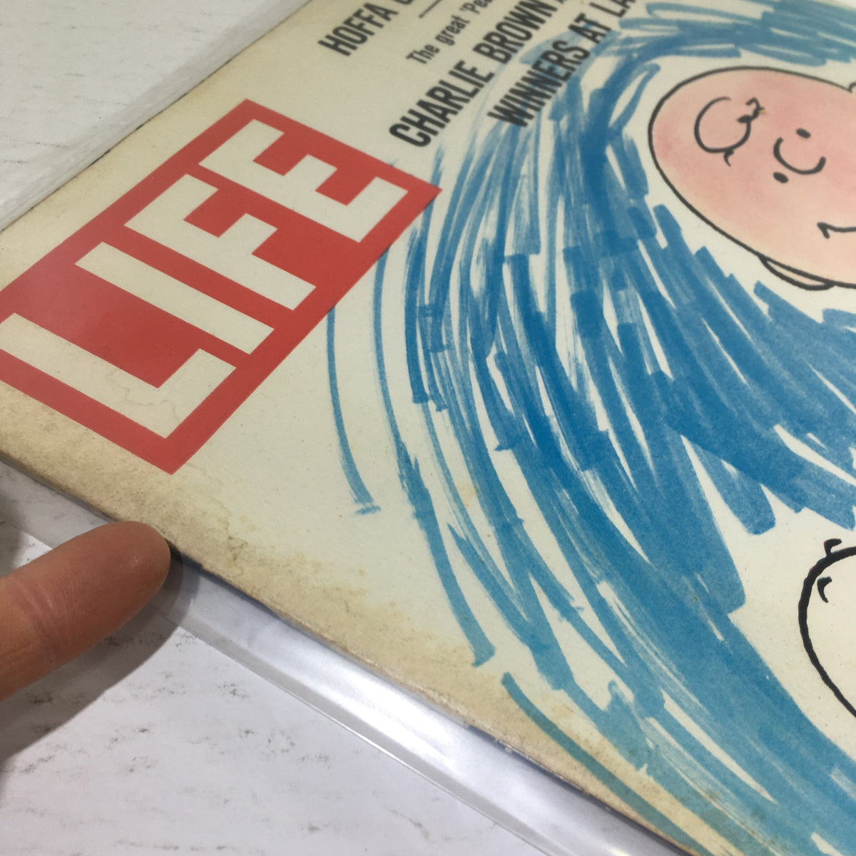 Close-up view of the Vintage Life Magazine cover from March 17, 1967, displaying the title 'LIFE' prominently. The cover features an illustration of Charlie Brown and Snoopy, highlighting details of age and wear.