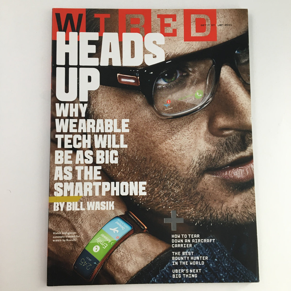Wired Magazine January 2014 cover featuring the title 'Heads Up: Why Wearable Tech Will Be As Big As The Smartphone' by Bill Wasik. The cover showcases a close-up image of a man wearing glasses and a wearable tech device on his wrist, emphasizing the integration of technology into everyday life.