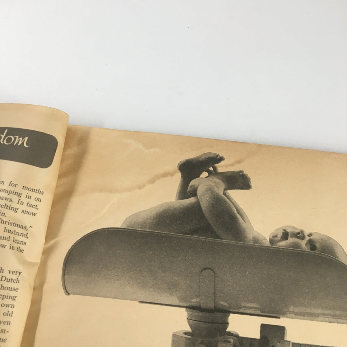 An interior page from the VTG Family Circle Magazine December 1960, featuring a nostalgic photograph of a playful baby lying in a traditional scale, emphasizing the vintage style and holiday theme of the issue, which includes a Christmas ghost story.