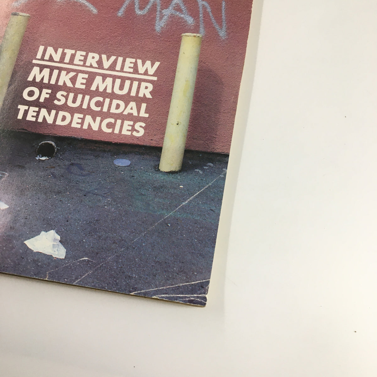 Side view of the VTG Thrasher Magazine May 1987 cover highlighting the interview with Mike Muir of Suicidal Tendencies, with a focus on the background graffiti and urban aesthetic.