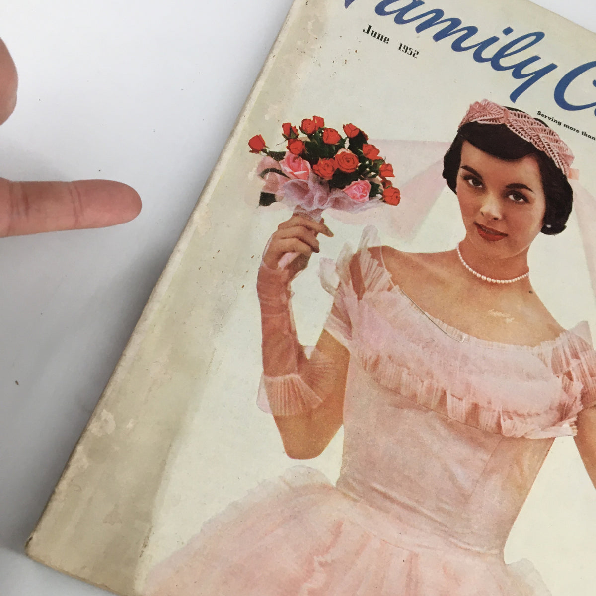Close-up of Family Circle Magazine June 1952 cover showing a bride in a pink dress with a bouquet, emphasizing the vintage theme 'The Bride Chooses Pink'.