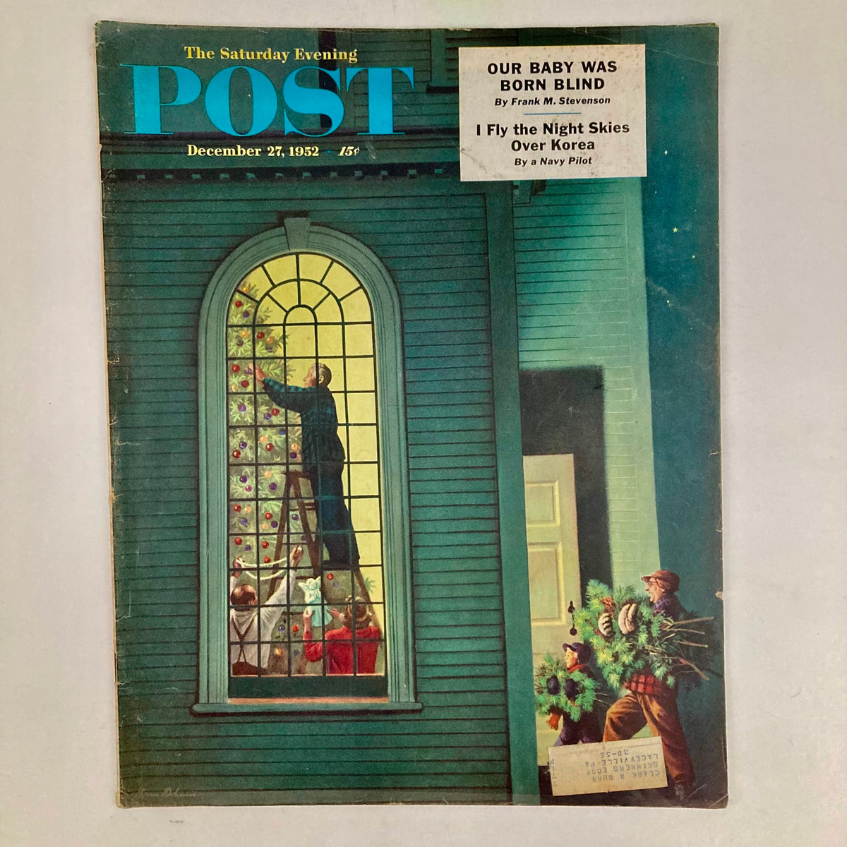 Cover of the Saturday Evening Post Magazine December 27, 1952, featuring an illustrated scene by Stevan Dohanos showing a man decorating a Christmas tree with a family watching, capturing mid-20th-century American holiday spirit.
