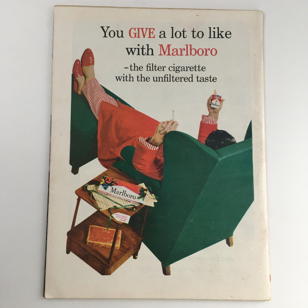Vintage Marlboro advertisement featuring a relaxed figure enjoying a cigarette, showcasing the tagline 'You GIVE a lot to like with Marlboro', emphasizing the brand's appeal.