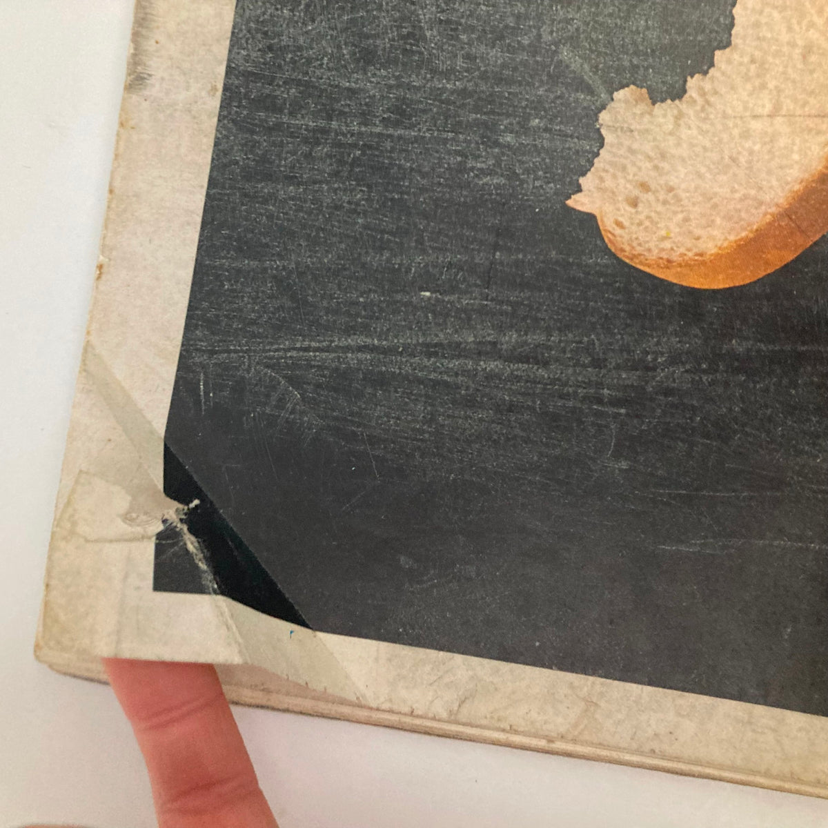 Close-up of the back cover of the Saturday Evening Post Magazine February 7 1948, illustrating a damaged area of the advertisement discussing bread and hunger, with a focus on the bitten piece of bread.