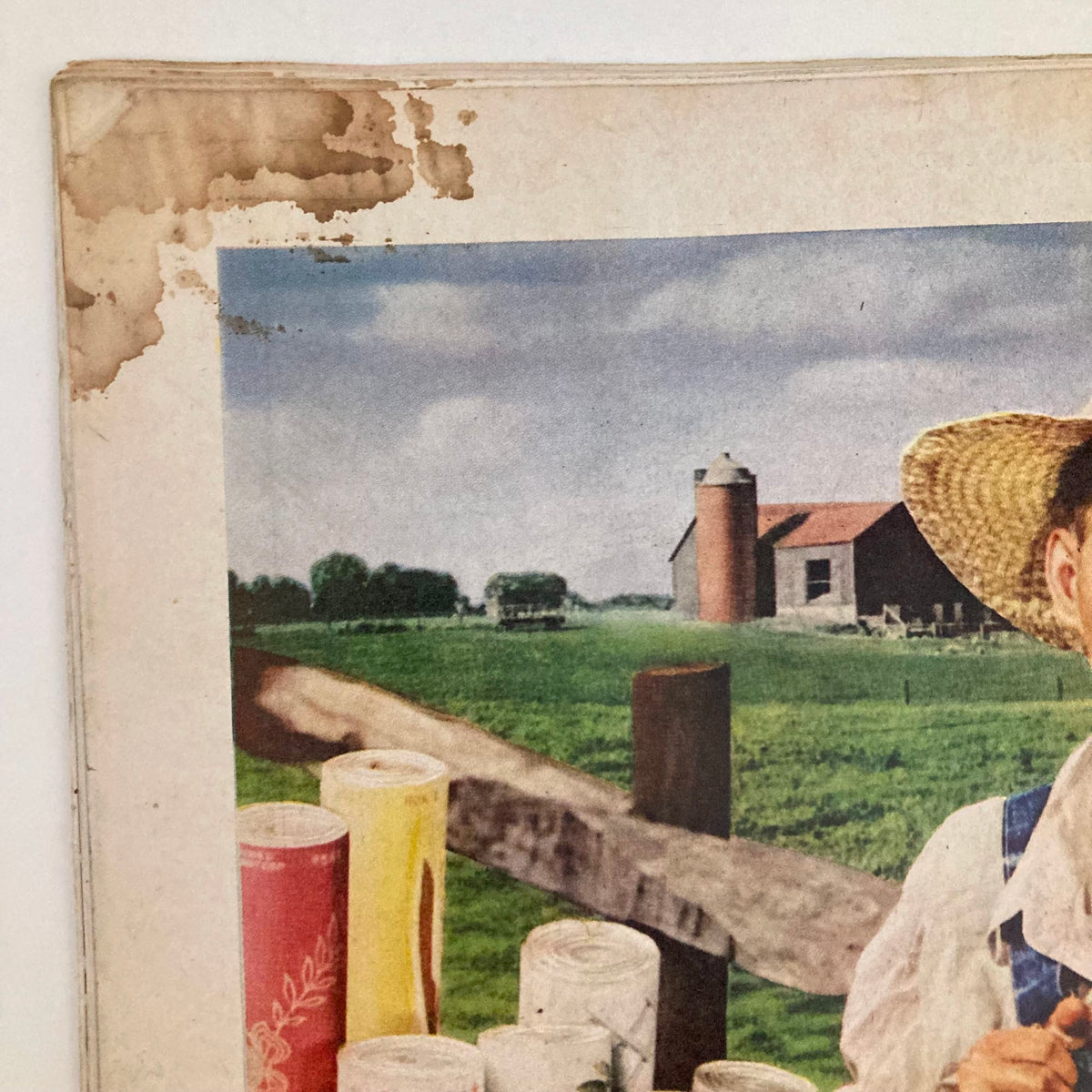 Close-up of a vintage advertisement featuring a farmer with a straw hat and colorful wallpaper rolls in the Saturday Evening Post Magazine February 17, 1945.