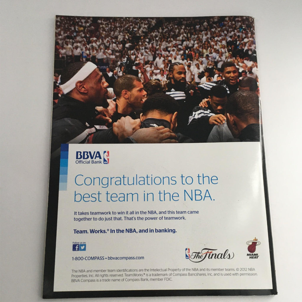 Back cover of Sports Illustrated Magazine 2012 NBA Champions Miami Heat, displaying a congratulatory message from BBVA, highlighting teamwork and featuring a group of players in a huddle.