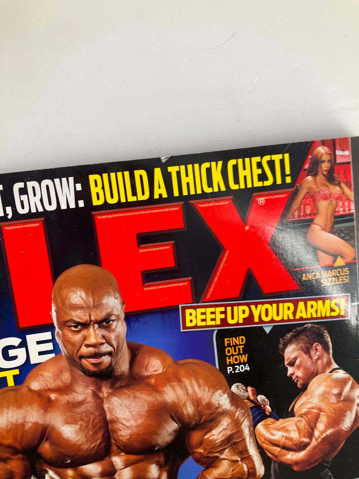 Close-up of Flex Magazine February 2011 cover highlighting Toney Freeman's physique and Anca Marcus in red lingerie, promoting the theme of strength and fitness.
