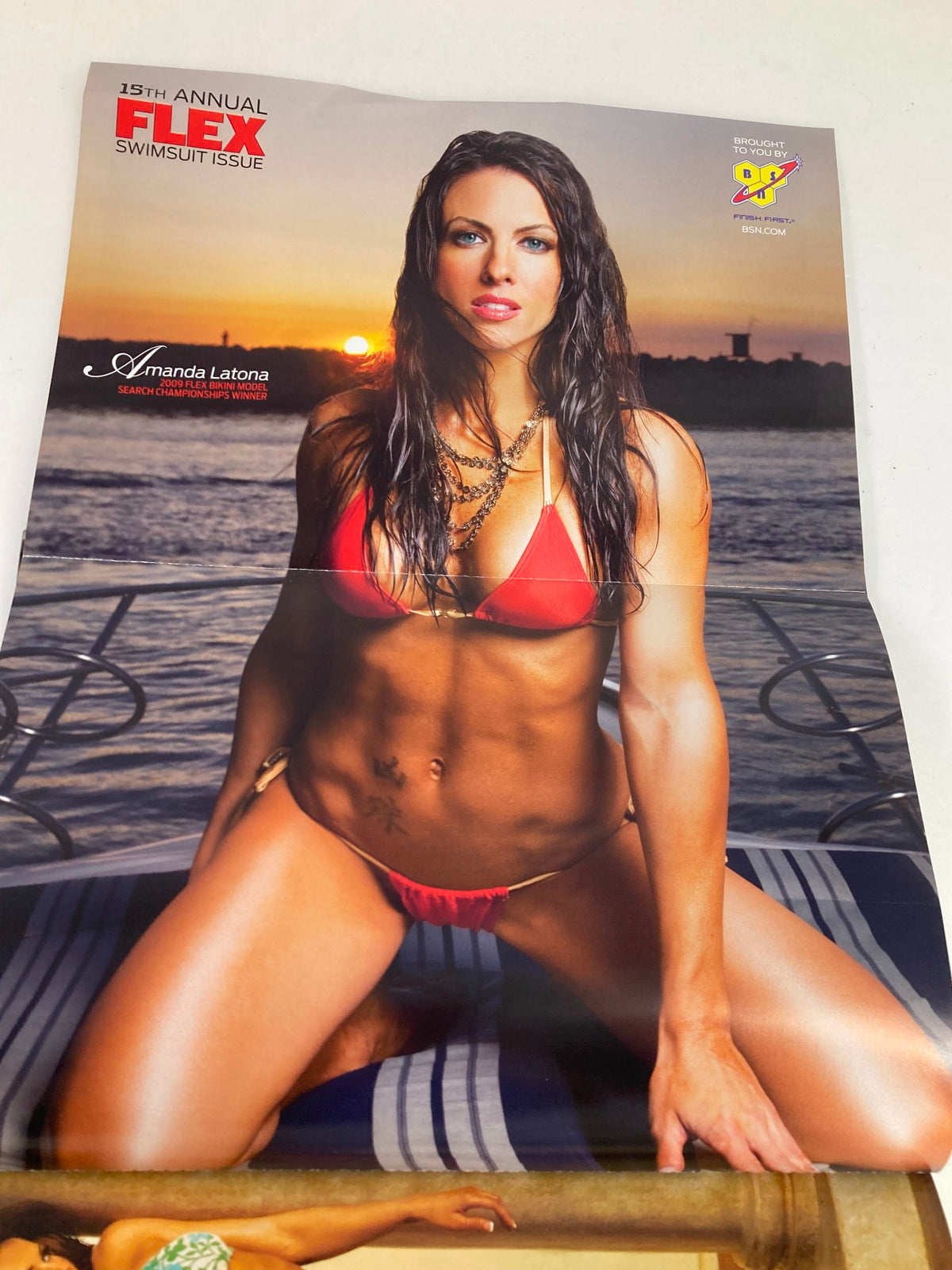 Poster from the June 2010 issue of Flex Magazine featuring Amanda Latona in a striking red bikini, promoting the annual swimsuit issue and showcasing fitness ideals.