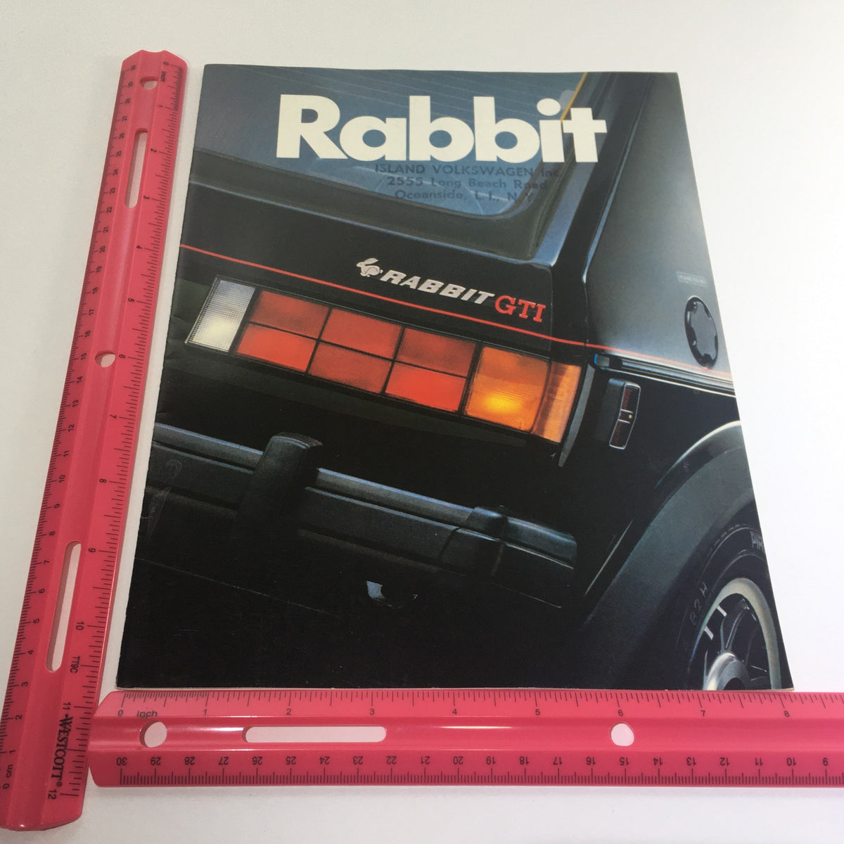 Front cover of the 1983 Volkswagen Rabbit GTI GL Dealership Car Auto Brochure Catalog with a ruler for scale, highlighting the 'RABBIT GTI' branding and design.
