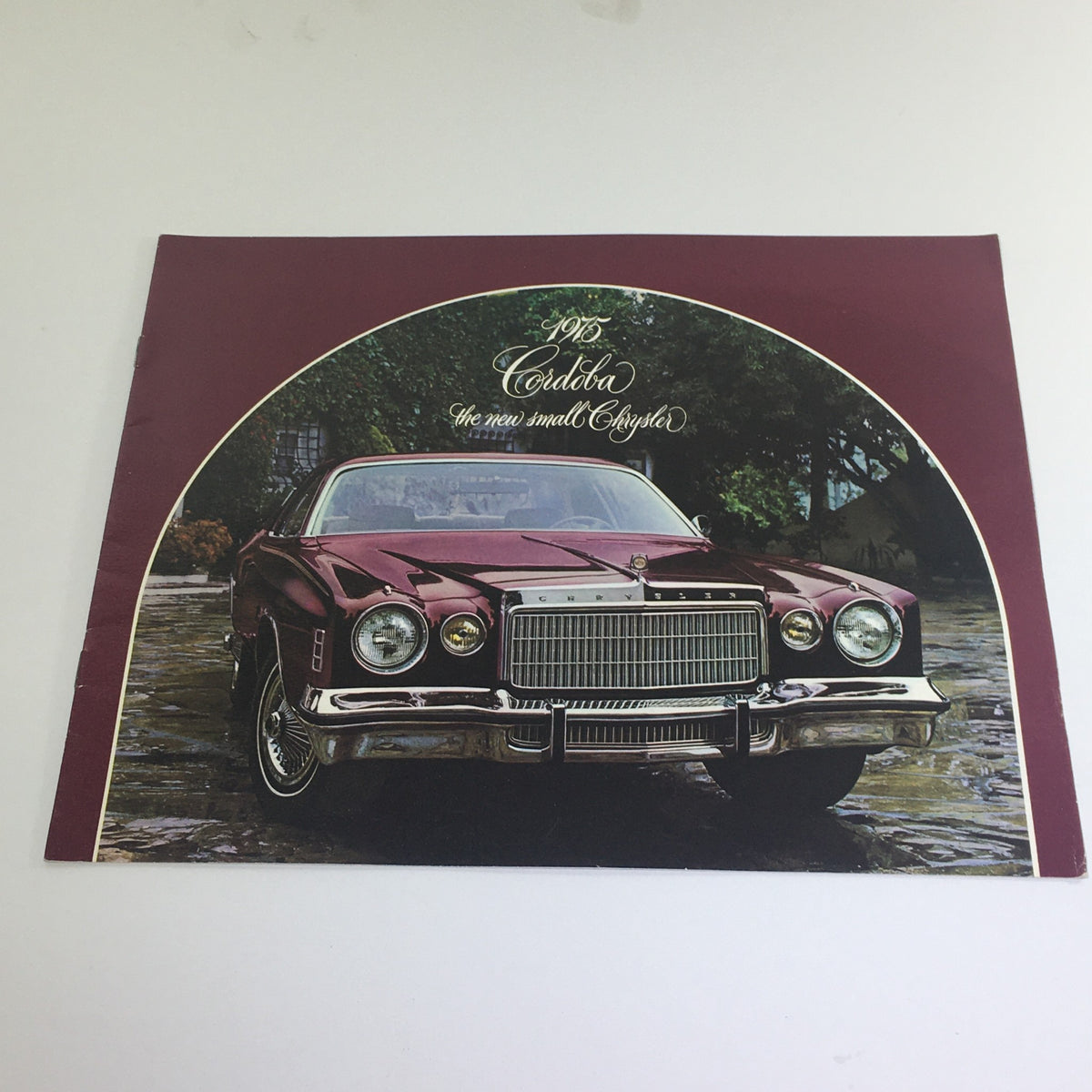 1975 Chrysler Cordoba Showroom Dealership Car Sale Auto Brochure Catalog featuring a classic burgundy Chrysler Cordoba parked on a scenic stone pathway.