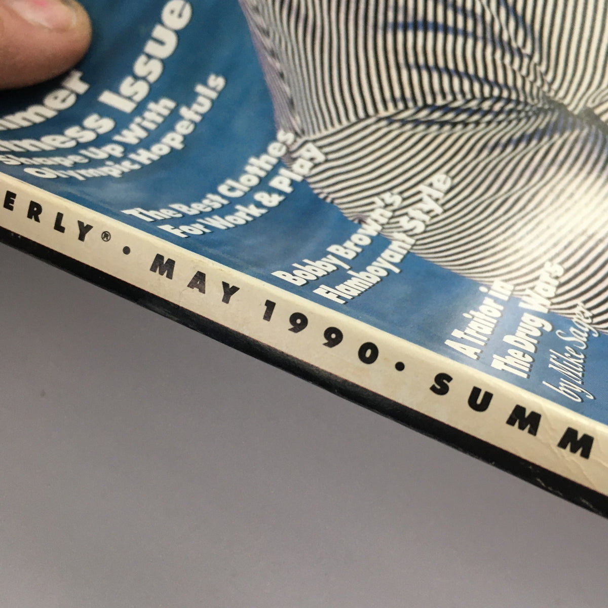 Close-up of the GQ Magazine May 1990 spine, clearly displaying the publication date and issue details, emphasizing its vintage nature and collectibility.