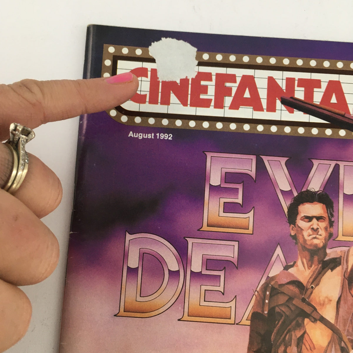 Close-up of the Cinefantastique August 1992 magazine cover highlighting the title and Bruce Campbell's character Ash from Sam Raimi's Army of Darkness. The image shows a hand pointing at the magazine logo.