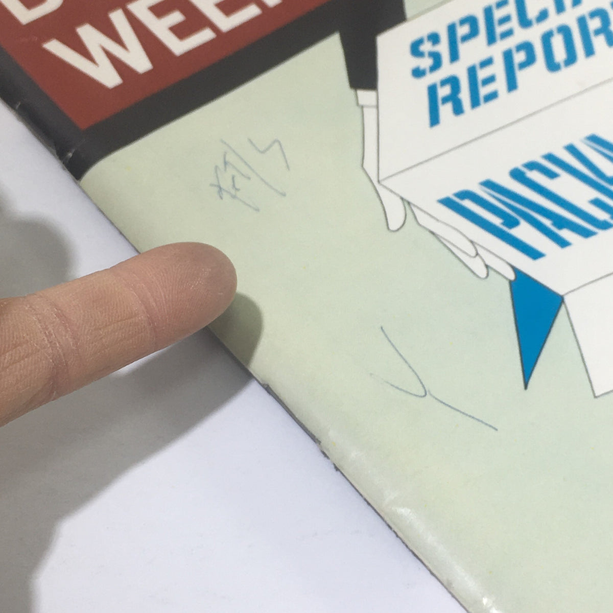 Close-up of the cover of Business Week Magazine: February 20, 1965, highlighting the special report on packaging, with a finger pointing at the design.
