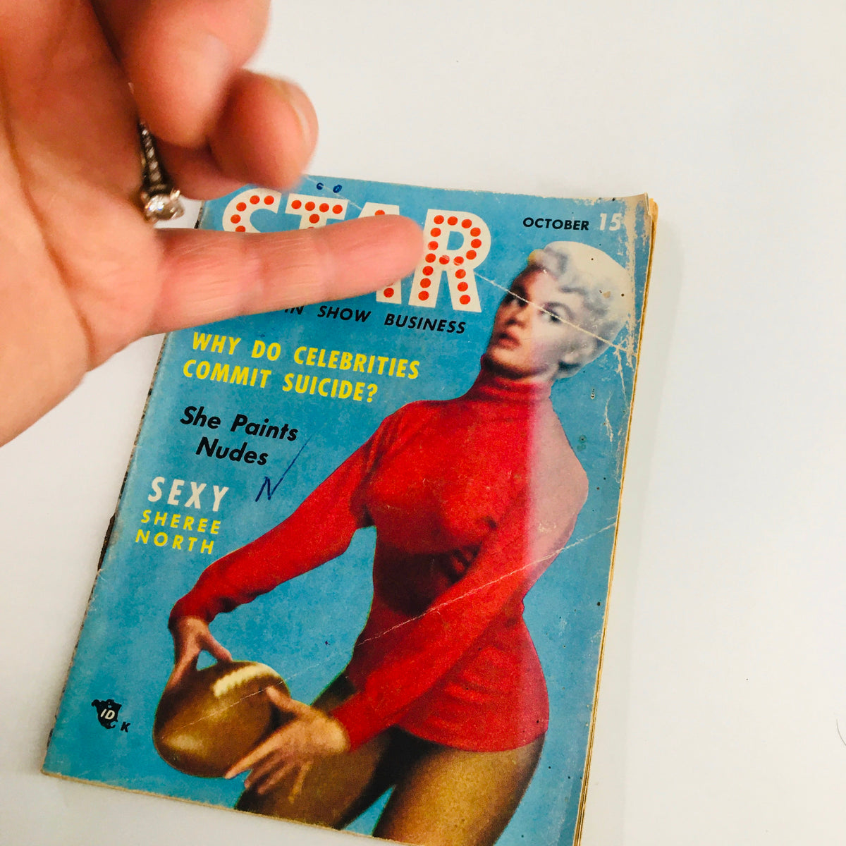 Close-up of Star Tabloid Magazine October 1954 cover highlighting the title 'Star' with a woman in red, discussing celebrity culture and the feature on suicide.