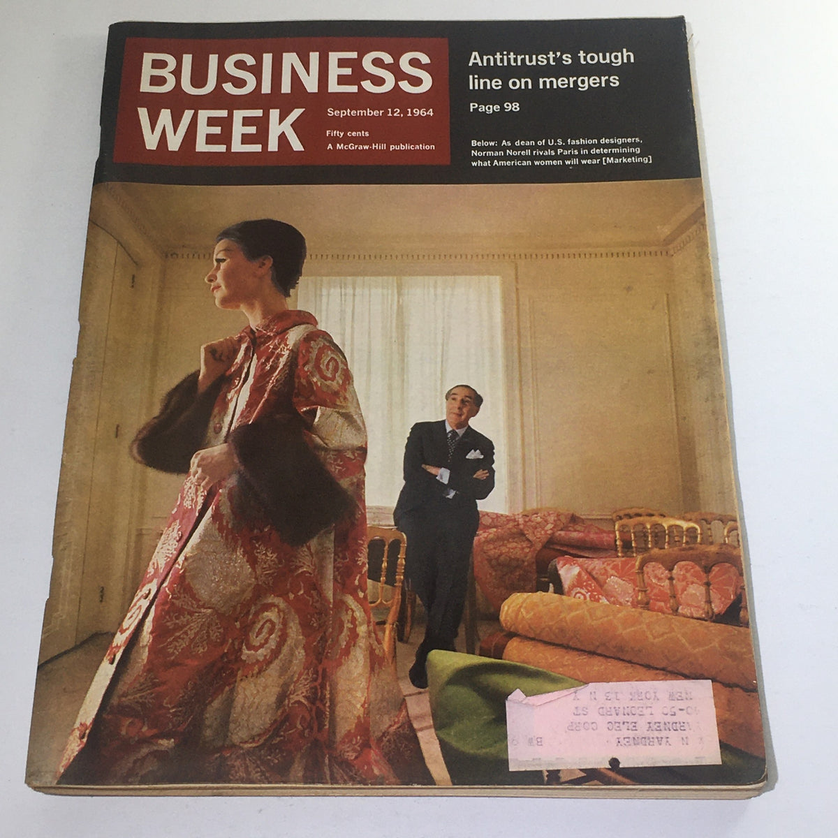 Cover of Business Week Magazine dated September 12, 1964, featuring a model in a luxurious Norman Norell gown, illustrating the American fashion designer's rivalry with Parisian designers.
